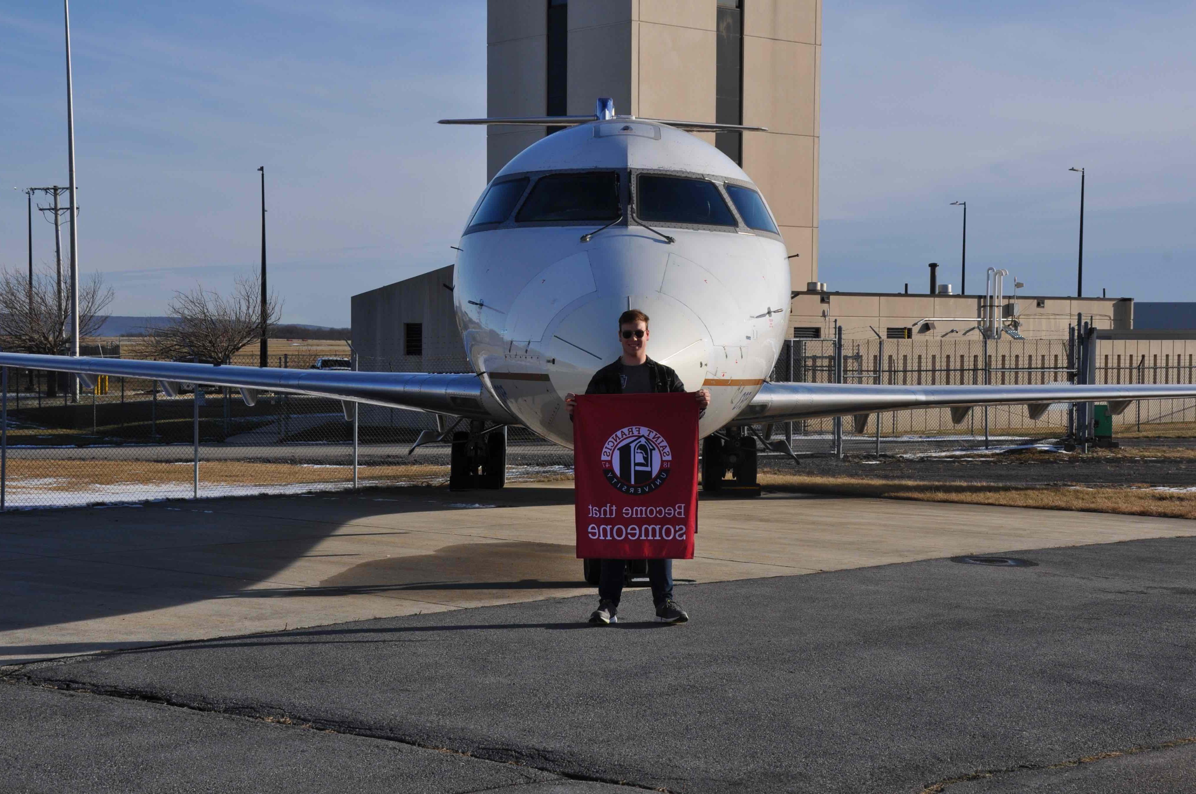 欧宝体育app入口的学生休·弗拉纳根站在一架由西天空航空公司捐赠给SFU的CRJ200机身前，该机身将作为未来航空技术员计划的一部分 